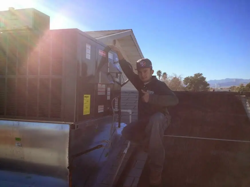 HVAC technician performing Heat Pump Repair on a rooftop unit in Kasson